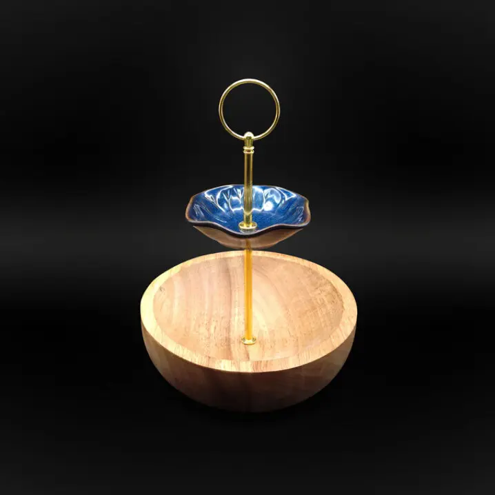Etagere mit einer runden Holzschale unten und einer blauen, blütenförmigen Schale oben mit goldenem Griff in der Mitte
