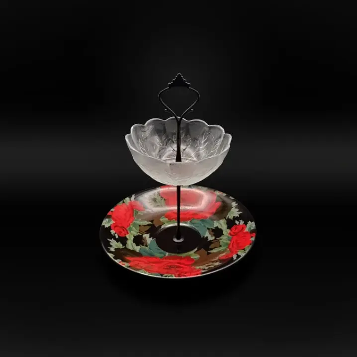 Zweistufige Etagere mit schwarzem Metallständer; oben eine transparente Glasschale mit Blütenform, unten ein Teller mit roten Rosen auf dunklem Hintergrund.