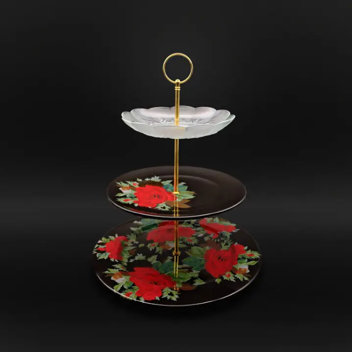 Dreistöckige Etagere mit goldfarbenem Griff oben und zwei schwarzen Tellern mit roten Rosenmotiven sowie einem weißen, blütenförmigen Teller oben